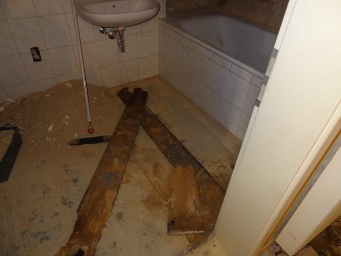 Geöffneter Boden mit durch den Echten Hausschwamm zerstörten Holzbalken